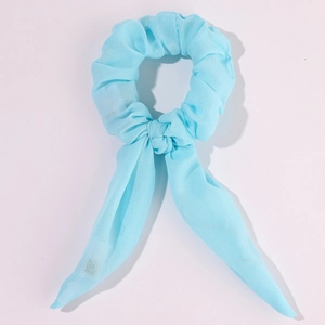 Close-up of light blue chiffon bow scrunchie with long ribbons on white background