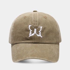 Macro shot of white butterfly embroidery detail on washed cotton baseball cap