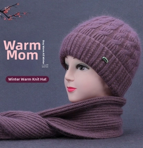 Detail of purple knitted winter hat and scarf set with thick cable pattern and metal badge