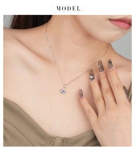 Close-up of model wearing evil eye pendant necklace with blue spinel and silver chain
