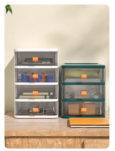 Detail of stacked desktop organizers showing semi-transparent drawers and orange pull handles