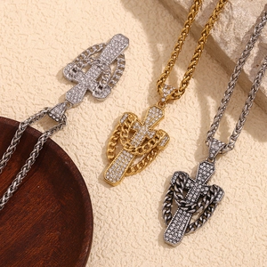 Close-up of three cross pendants with rhinestones on Cuban link chains in gold and silver