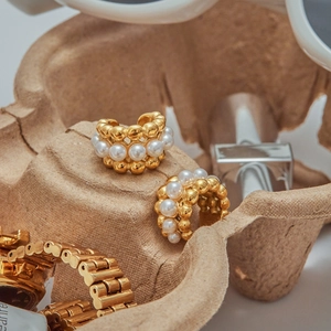 Macro detail of 18K gold plated hoop earrings with white pearls and layered structure