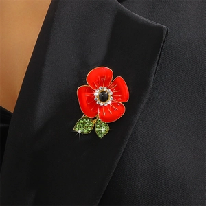 Poppy flower enamel brooch with red petals and crystal leaves on a black suit lapel