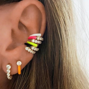 Macro detail of U-shaped enamel earrings with pavé zircons worn on model's ear