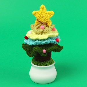 Detail of a handmade crochet Christmas tree with yellow star in a white ceramic pot