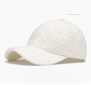 Detailed close-up of an off-white crochet baseball cap showing fine knit texture