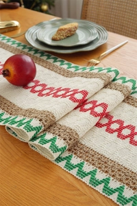 Close-up of woven cotton linen table runner with Christmas tassels and geometric patterns