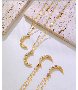 Detailed macro view of four gold hammered crescent moon pendants on fine link chains