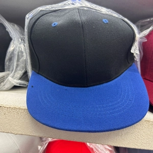 Detail view of contrast color flat brim cap with blue reinforced stitching and eyelets