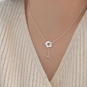 Close-up of a 925 sterling silver flower pendant necklace with OT toggle clasp on a model