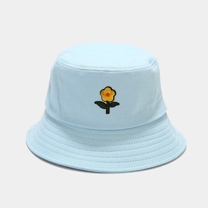 Dettaglio ravvicinato del ricamo floreale giallo sul cappello a secchiello blu