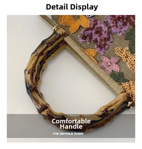 Detail view of floral embroidery and resin bamboo handle on a linen handbag