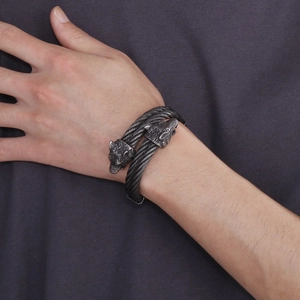 Close-up of punk rock wolf head cable bracelet with twisted metal texture on wrist