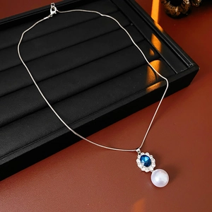 Macro di collana in argento con pietre preziose blu ed eleganti pendenti di perle