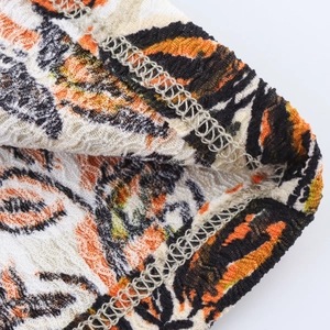 Makro-Detail des Strickstoffs mit abstraktem Tigerprint und feiner Verarbeitungsnaht