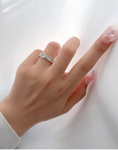 Detail of s925 silver eternity ring with emerald cut cubic zirconia on a model hand
