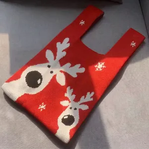 Close-up of a red Christmas knit tote bag showing white reindeer and snowflake patterns