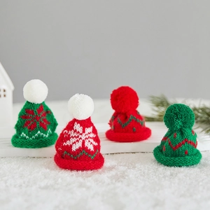 Mini knitted Christmas hats in red and green with snowflake patterns for holiday decor