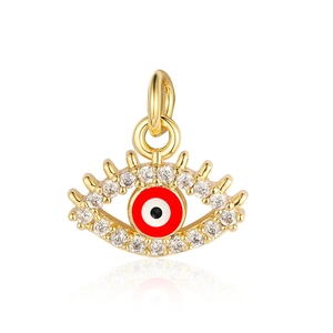 Macro detail of golden evil eye charm with red enamel and sparkling zircons