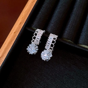 Detailed close-up of C-shaped flower earrings with sparkling zircons on black velvet