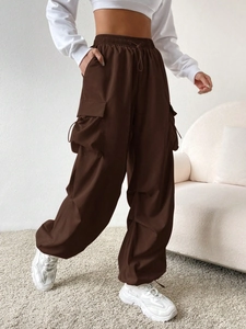 Detailed view of women's dark brown cargo pants featuring large pockets and elastic drawstrings