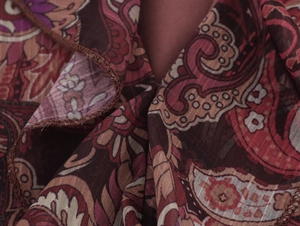 Makroaufnahme von Chiffonstoff mit Paisley-Muster, feinen Saumnähten und Volants