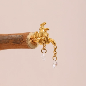 Macro shot of 18K gold faucet earrings with crystal droplets hanging from metal chains