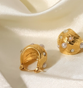 Vue macro de boucles d'oreilles créoles dorées 18K avec perles et cristaux sur soie