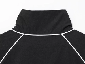 Detail of black nylon puffer jacket featuring a stand collar and white contrast piping