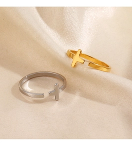 Detail of adjustable cross rings in gold and silver finish on soft silk fabric