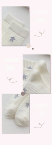 Detail view of white cotton socks featuring gray star patterns and reinforced ribbing