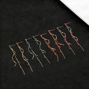 Detail of four long tassel earrings with marquise-cut zircons in gold and silver plating