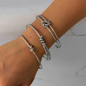 Ensemble de trois bracelets joncs en acier inoxydable argenté avec nœud et spirale