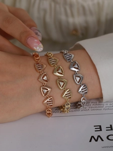 Detailed close-up of geometric triangle zircon bracelets in rose gold, gold, and silver finishes