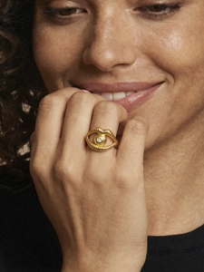Detailed view of gold lip and eye ring with sparkling zircon stone on model