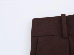 Detailansicht der dunkelbraunen Twill-Bundschlaufen und der feinen Stofftextur der Hose