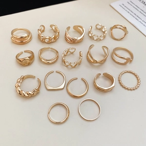 Detailed overhead view of 16-piece gold starfish and heart geometric ring set on beige