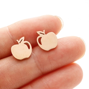 Macro shot of rose gold apple-shaped stud earrings featuring minimalist hollow design