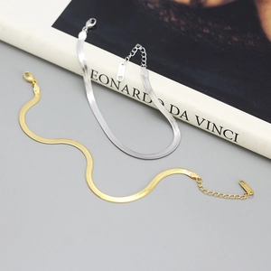 Flat lay of minimalist gold and silver S925 sterling silver flat snake bone chain bracelets