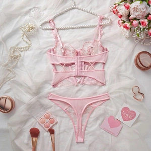 Flat lay of pink floral lace lingerie set with roses, pearls and mesh detail
