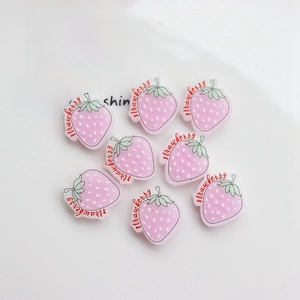 Close-up of pink resin strawberry charms for DIY crafts and phone case decoration