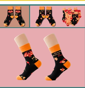 Detail of knit Thanksgiving socks featuring black turkey patterns and orange accents