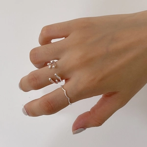 Detail shot of three 925 sterling silver minimalist wavy rings worn as a stacked set