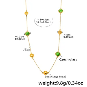 Détail du long collier en acier inoxydable doré avec perles en verre tchèque vert et or