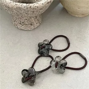 Close-up of three jelly acrylic flower hair ties with marble texture and elastic bands