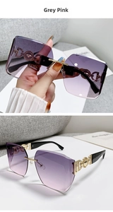 Detail of grey pink gradient lenses and gold logo on oversized rimless sunglasses