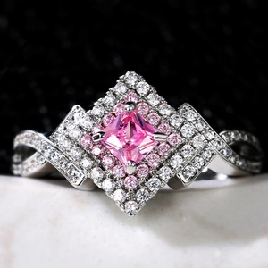 Lussuoso anello con zaffiro rosa, doppio alone di diamanti e fascia incrociata in argento