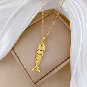 Détail d'un pendentif carpe koï dorée avec écailles articulées et œil en gemme rouge