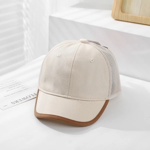 Close-up of mesh baseball cap with ivory canvas and brown brim on a white step